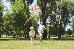 快乐的父亲和可爱的儿子玩科罗弗鲁在公园放风筝