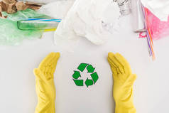 部分人的看法在黄色橡胶手套在玻璃瓶、塑料袋、纸和塑料管与回收标志 