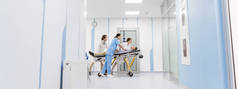 集中的医生和护士在轮床上运送无意识病人 