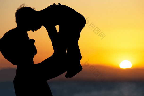 父亲和小儿子-上海滩日落时的剪影