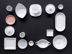黑色背景上的白色和彩色餐具的集合 