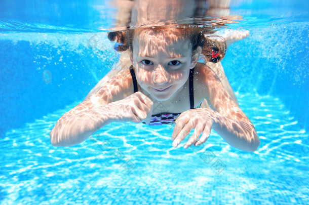 快乐的女孩游在<strong>水下</strong>，游泳池游泳、 踢球和玩乐的好动小孩，儿童水运动