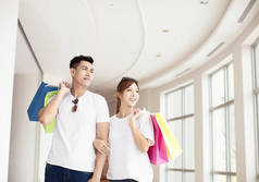 年轻夫妇与购物袋步行在购物中心