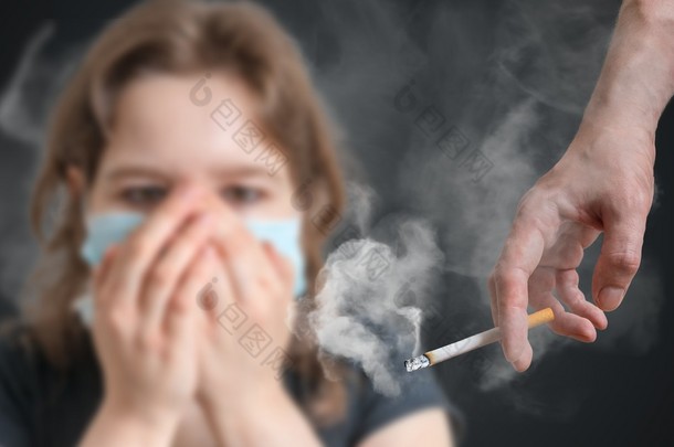 被动吸烟的概念。女人的脸被香烟的烟雾蒙住了.