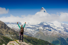 女人的徒步旅行者张开双臂在山