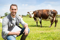 一位年轻迷人的兽医在牧场上放牛的画像