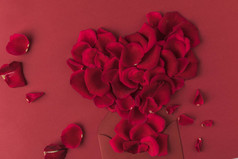 红玫瑰花瓣和信封的心的顶部视图