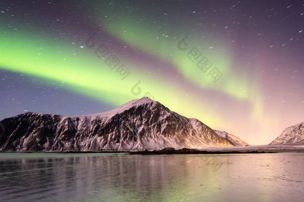 罗弗敦群岛上的北极<strong>极光</strong>, 挪威。山上的绿色北<strong>极光</strong>。夜空中的极地灯光。夜间冬季景观与<strong>极光</strong>和倒影在水面上。自然背景在挪威
