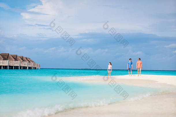 父亲和孩子们在热带岛屿享受夏季海滩度假