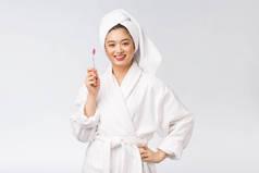 亚洲快乐女人，牙刷在浴袍的早晨心情