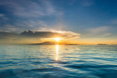 美丽的海滩日落与蓝色的大海和金色的光天空云