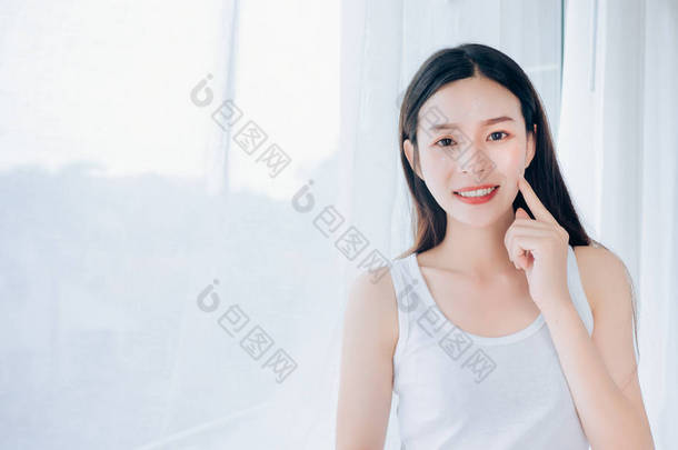 年轻美丽的亚洲女人清晰的脸护肤她的快乐和微笑在白色的<strong>房间</strong>, 复制空间.