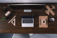 台式电脑, 笔记本电脑和办公用品在木桌上的最高视图 