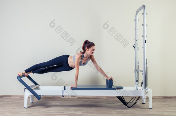 普拉提的改革者锻炼锻炼<strong>女人</strong>黑发在健身房室内