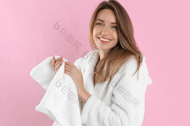 年轻女子用淡粉色背景的毛巾擦拭双手