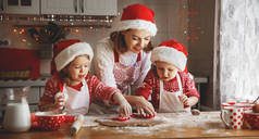 快乐家庭的母亲和儿童烤饼干的圣诞礼物