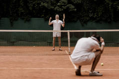 复古风格的网球选手在网球场赢得比赛后显示是手势