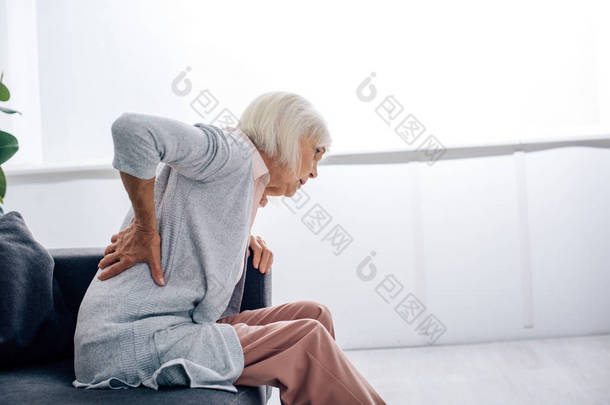 老年妇女在公寓<strong>背痛</strong>的侧视 