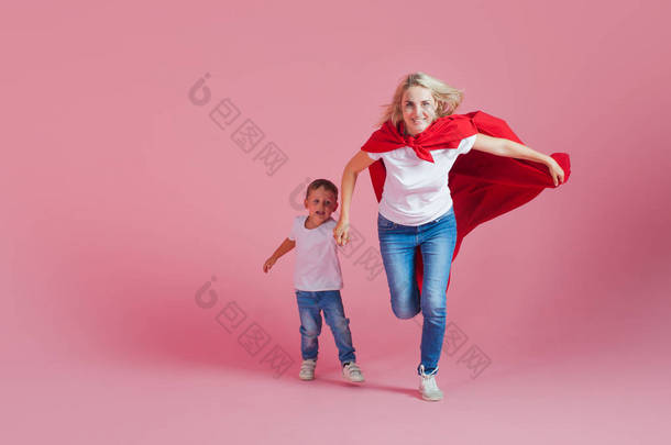 <strong>超级妈妈</strong>和她的儿子向前跑。有趣的家庭, 一个年轻的金发女子在红斗篷作为<strong>超级</strong>英雄