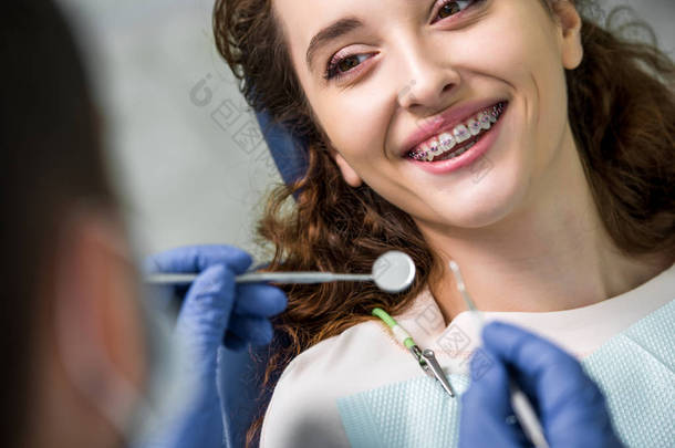 在牙医附近检查牙齿时, 用牙套关闭快乐的妇女