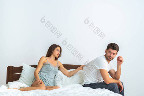 那个不幸的男人和一个女人坐在床上，背景是白的