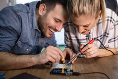 两位年轻的商业伙伴技术员专注于修理电子设备