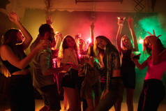 一群人站在轮廓上，在霓虹灯的衬托下手拉手地跳起舞来
