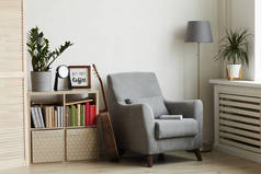 现代简约室内环境中舒适的阅读角落的背景图像，聚焦于靠墙的灰色扶手椅上，复制空间