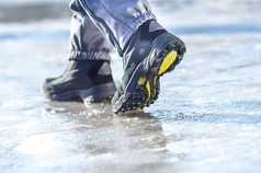 冬季穿的皮靴在白雪皑皑的雪道上行走