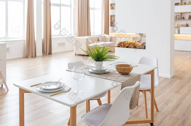 室内设计宽敞明亮的工作室公寓斯堪的纳维亚风格和温暖的乳白色和米黄色的色彩。客厅里时髦的家具和厨房里的现代细节