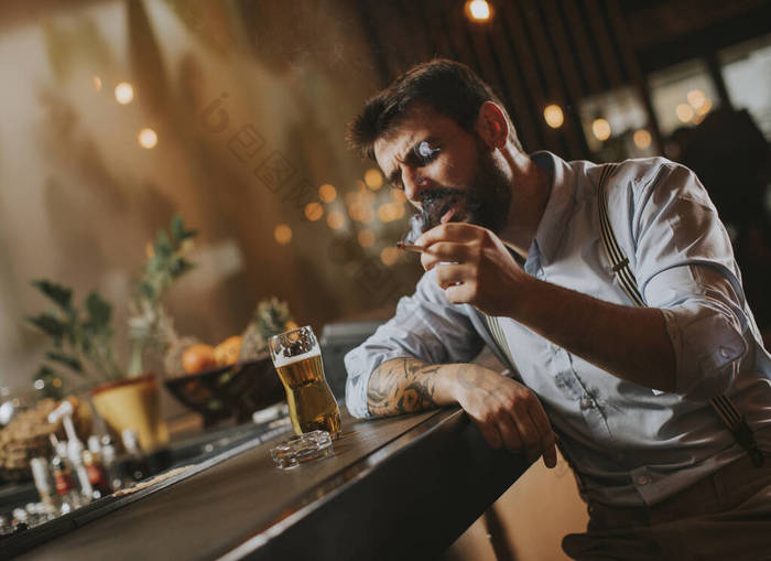 晚上在酒吧喝啤酒抽烟的男人