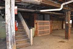 仓库的地下室是空的，里面有旧的横梁、天花板、电梯、管道和电线. 