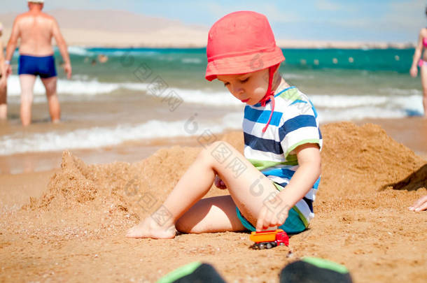 3岁<strong>幼儿</strong>在海边与玩具车的合影。儿童在<strong>暑假</strong>假期放松和享受乐趣.