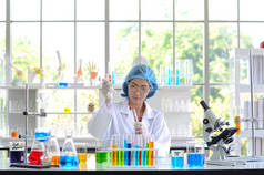 实验室中的女科学家用试管中的滴管合成化合物进行实验.