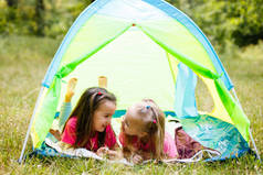 两个小女孩在公园的帐篷里玩耍。
