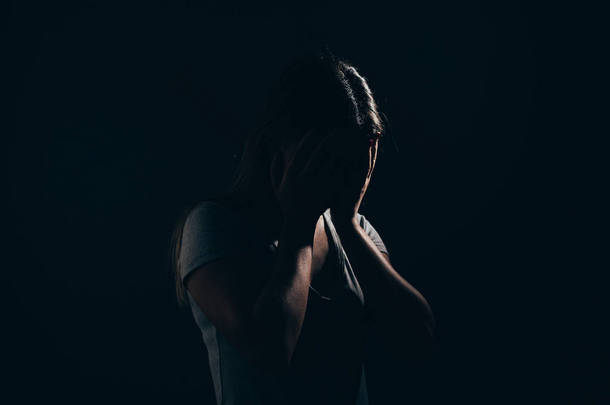 悲伤的女人在黑暗的房间。抑郁症和焦虑症的概念