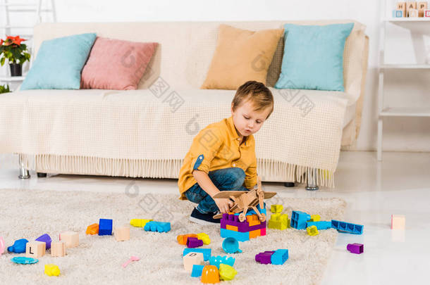 可爱的小男孩玩玩具飞机和五颜六色的<strong>街区</strong>在家里