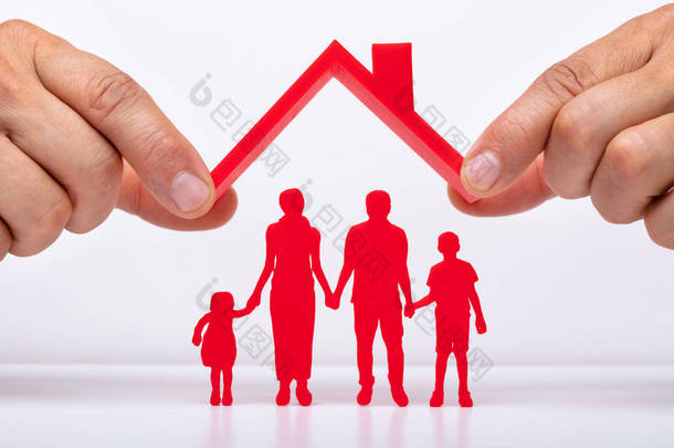 人手保护家庭人物与屋顶