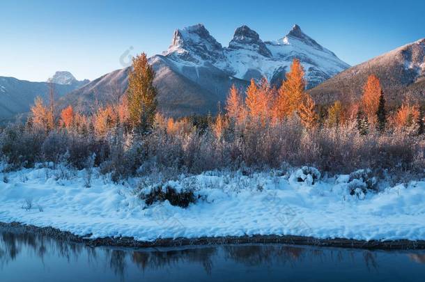 几乎完美地反映了弓江中的三姐妹峰。 加拿大艾伯塔省<strong>坎莫尔</strong>附近。 冬季即将到来。 熊国 美丽的景观背景概念. 