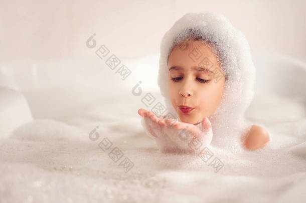 这个女孩在浴室里洗澡和<strong>玩耍</strong>泡沫。这是一个很大的下降。吹<strong>泡泡</strong>