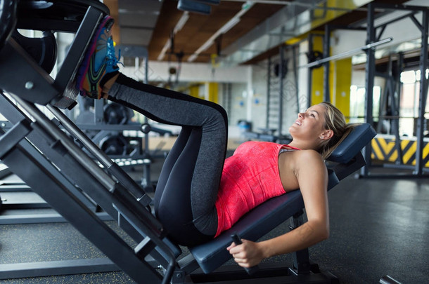 女人做压腿机上健身房运动