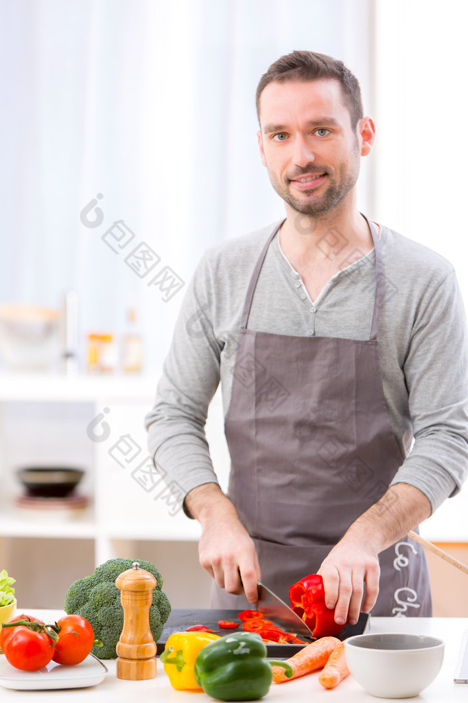 年轻有魅力的男人在厨房做饭