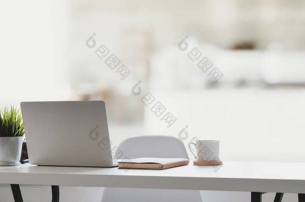 舒适的工作环境，配备笔记本电脑、咖啡杯和办公室用品，氛围轻松  