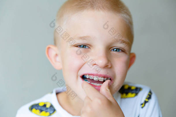 <strong>一个</strong>金发碧眼的男孩把<strong>一个</strong>刚出生的正牙盘插入他的<strong>嘴</strong>里。靠近点