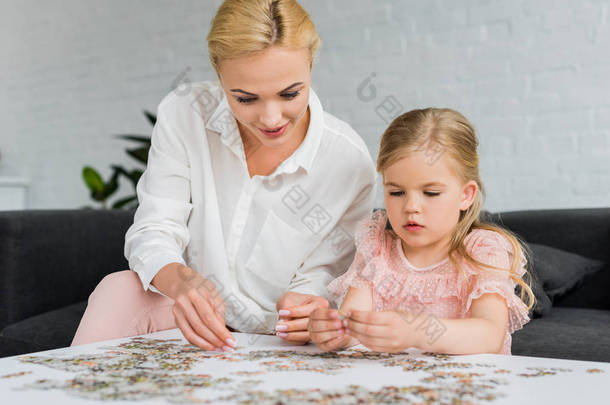 美丽的母亲和女儿玩拼图拼图在家里