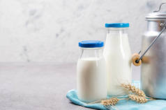 两瓶鲜牛奶和铝牛奶放在一张桌子上