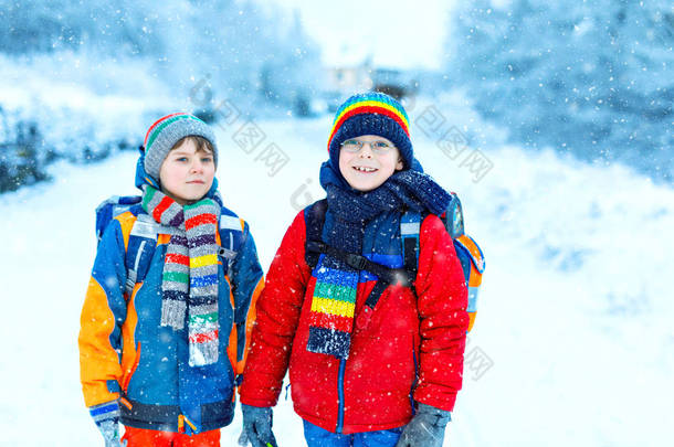 下大雪时，两个小学的小男孩步行去学校。快乐的孩子们玩的开心，玩的是初雪。姐姐们的朋友们，背着五颜六色的冬衣背包.