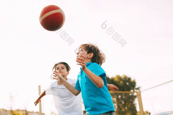 两个少年在操场上打篮球.运动员在比赛中为争取球而奋斗.健康<strong>的</strong>生活方式、运动、动机