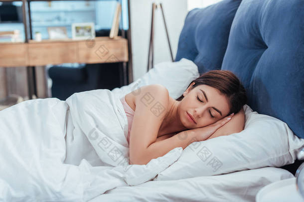 年轻美丽的女人睡在她的床上上午的时间在家里