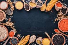 粗和谷物的集合。荞麦, 扁豆, 大米, 小米, 大麦, 玉米, 黑米。在黑色的背景。顶部视图。复制空间.